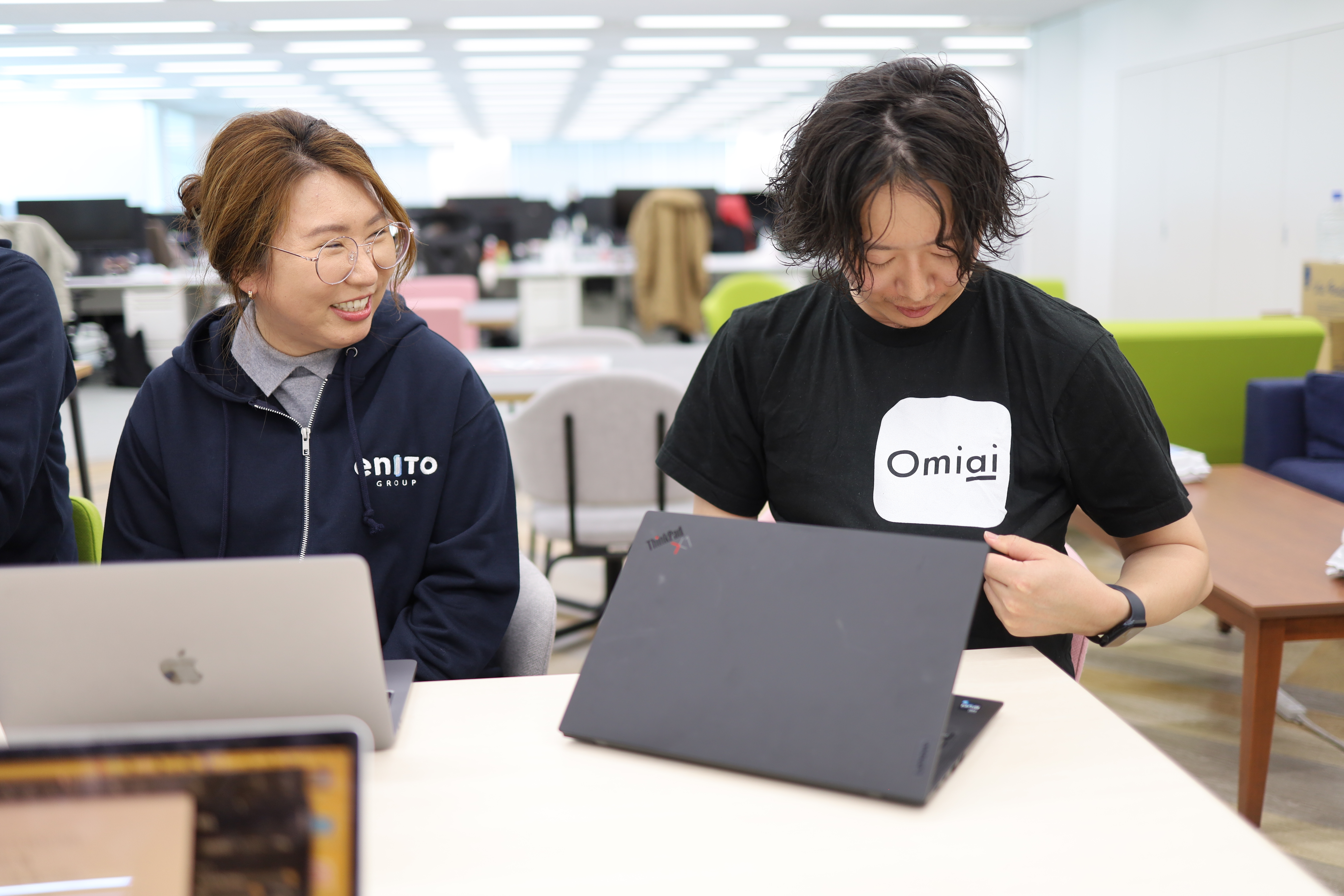 omiaiのTシャツを見せる竹内さん