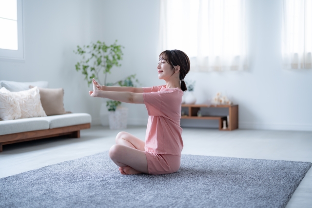 部屋でストレッチをする女性