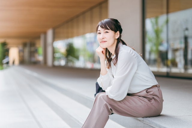 階段に座って待ち合わせ相手を待っている女性